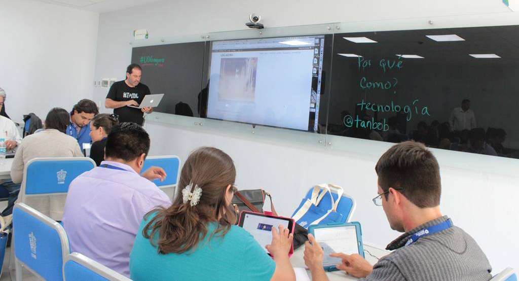 Profesor y estudiantes colaborando en un aula multimedia