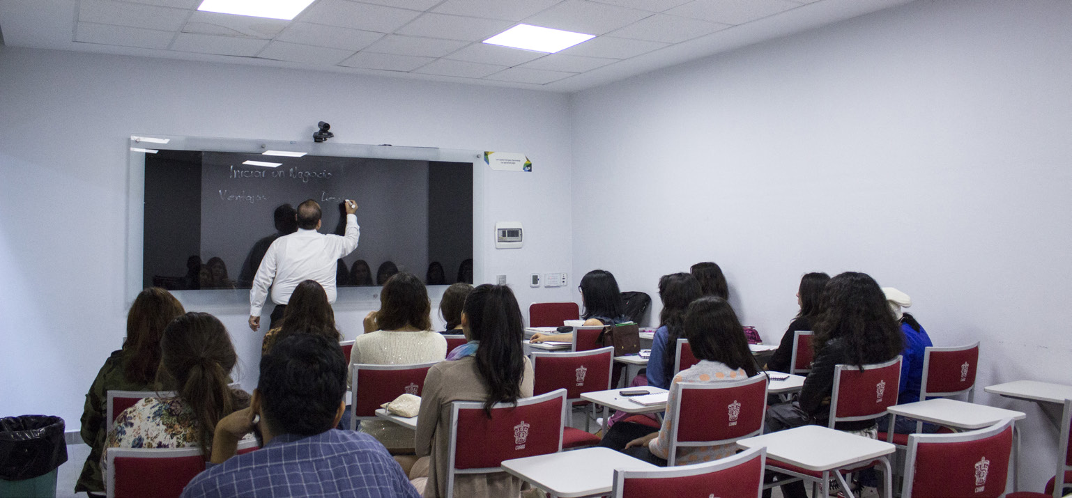 Pantalla en aula multimedia, con soporte de vidrio para escribir, en lugar de pintarrón o pizarrón