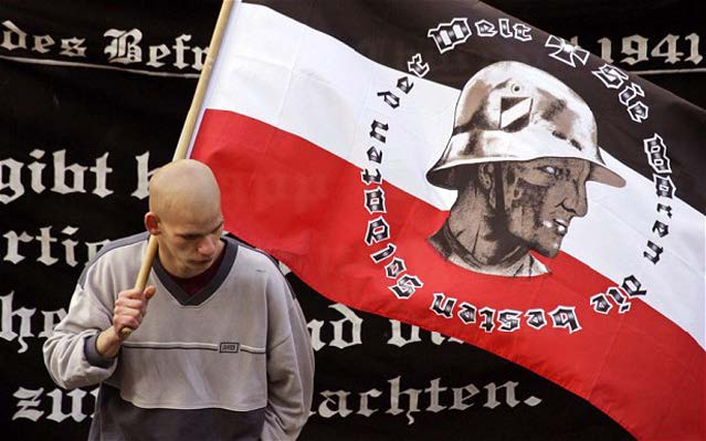 Un seguidor del partido neonazi alemán NPD sujeta una bandera durante una concentración